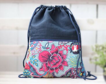 Mały lniany plecak w kolorze granatowym z kieszenią zapinaną na zamek. Plecak dla niej ze sznurkiem i bawełnianym orientalnym kwiatkiem